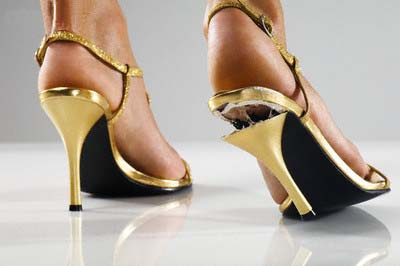Woman Wearing Gold Shoes with Broken Heel