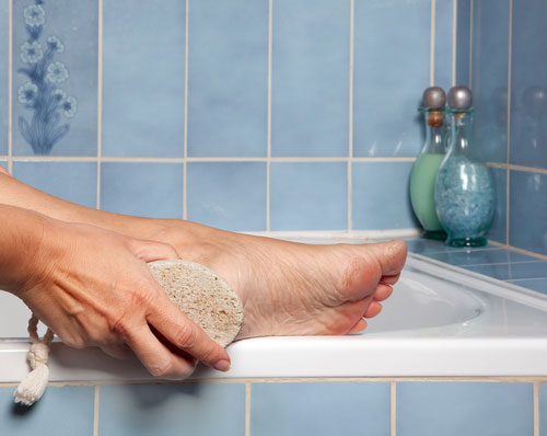 Foot Callus & Corn Removal-woman scrubbing calluses